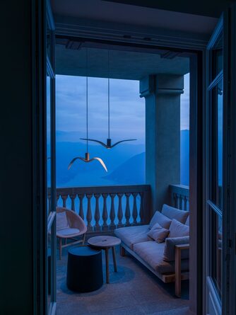 Zwei flügelförmige Night-Birds-Leuchten über der Sitzgruppe auf der Terrasse der Villa Peduzzi