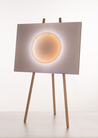 Moodmoon Framed mit warmem Lichtkreis auf einem dreibeinigen Holzstativ