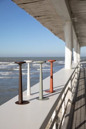 Vier Papiria Tischleuchten in Dunkelbraun, Weiß, Salbeigrün und Ockerrot auf einem Sims am Meer
